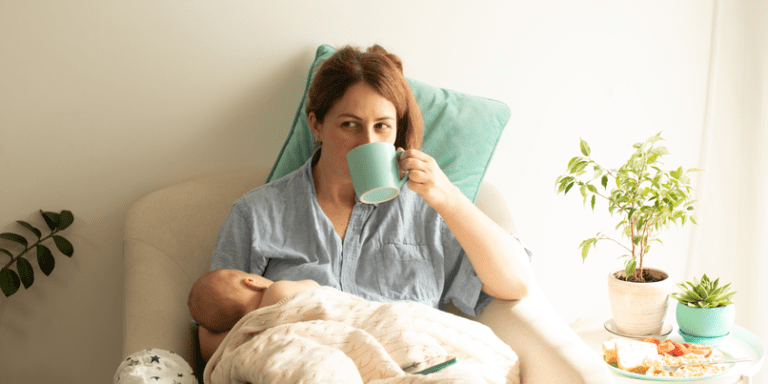 new mother relaxing & feeding her baby sipping tea