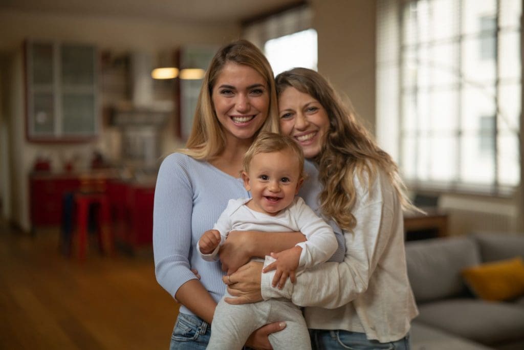 Same sex couple with child receiving postpartum support