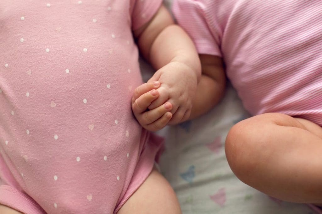 Twins dressed in pink spending their first night at home