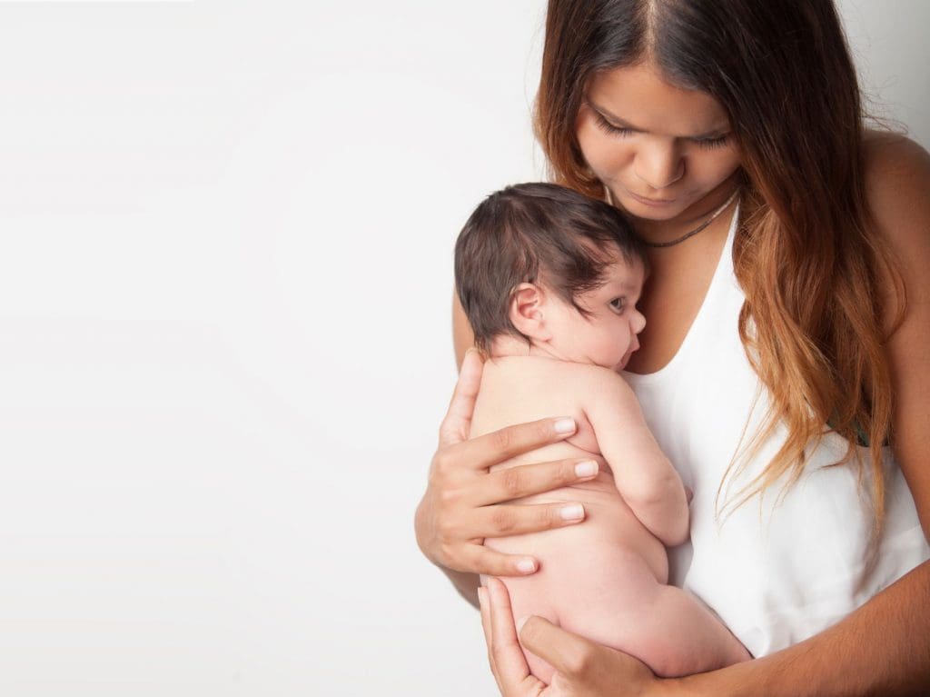 Woman cuddling newborn in Seaford
