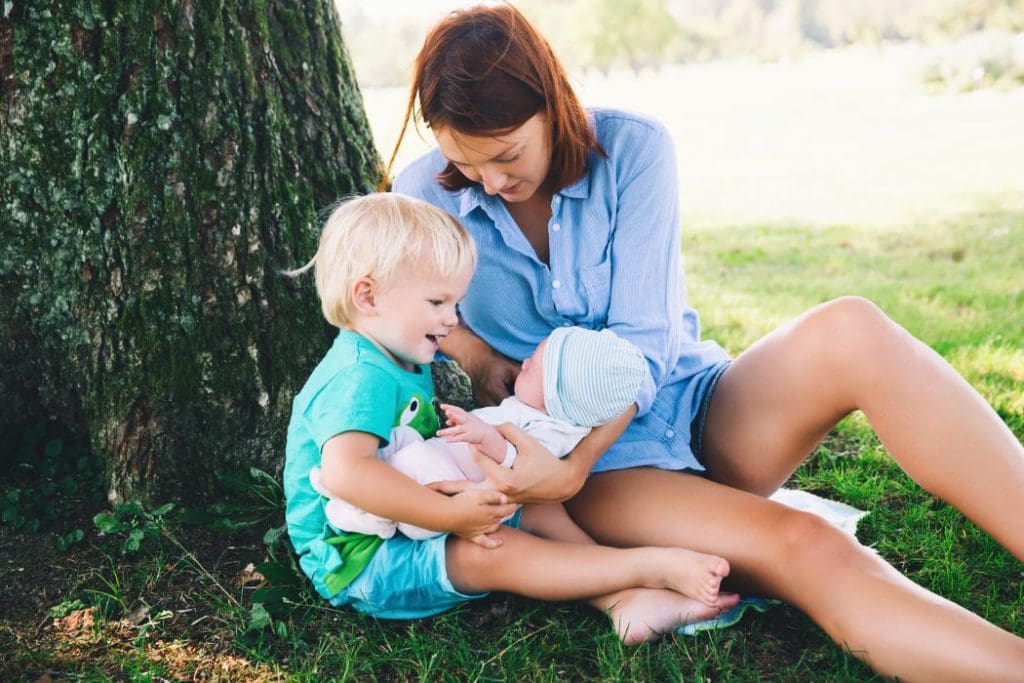 Woman with child and newborn relaxing in Warragul